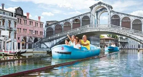 Persone navigano tra le riproduzioni in miniatura di Venezia a bordo di una gondola