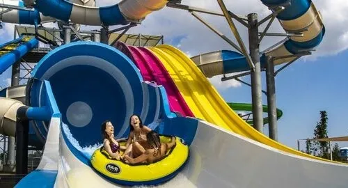 Ragazzi scendono da uno scivolo con gommone al parco acquatico MiraBeach di Mirabilandia