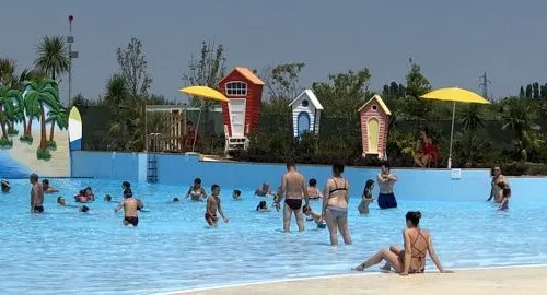 Persone che si divertino nella grande piscina onde del parco acquatico MiraBeach di Mirabilandia