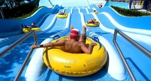 Bambino scende su ciambellone uno scivolo del parco acquatico di Tortoreto